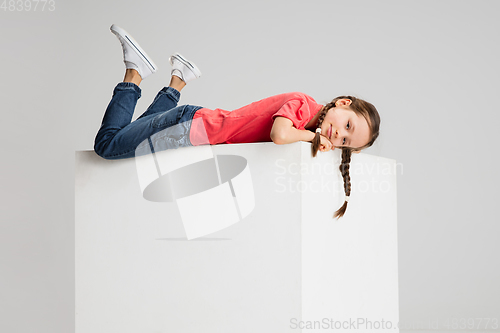 Image of Happy kid, girl isolated on white studio background. Looks happy, cheerful, sincere. Copyspace. Childhood, education, emotions concept