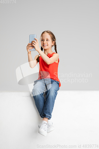 Image of Happy kid, girl isolated on white studio background. Looks happy, cheerful, sincere. Copyspace. Childhood, education, emotions concept
