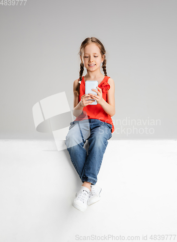 Image of Happy kid, girl isolated on white studio background. Looks happy, cheerful, sincere. Copyspace. Childhood, education, emotions concept