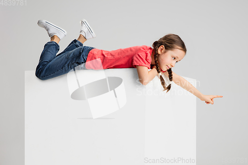 Image of Happy kid, girl isolated on white studio background. Looks happy, cheerful, sincere. Copyspace. Childhood, education, emotions concept