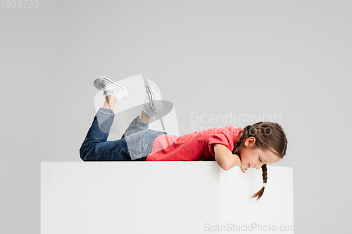 Image of Happy kid, girl isolated on white studio background. Looks happy, cheerful, sincere. Copyspace. Childhood, education, emotions concept