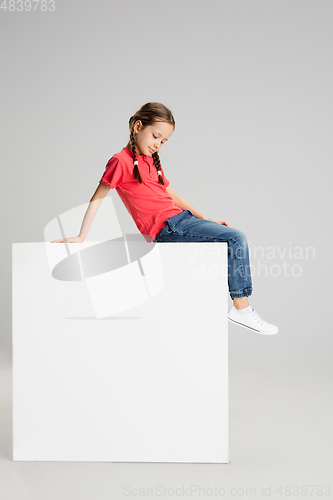 Image of Happy kid, girl isolated on white studio background. Looks happy, cheerful, sincere. Copyspace. Childhood, education, emotions concept