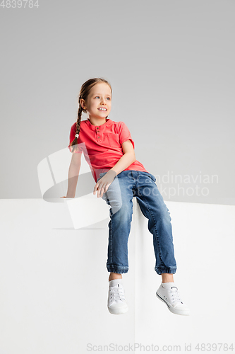 Image of Happy kid, girl isolated on white studio background. Looks happy, cheerful, sincere. Copyspace. Childhood, education, emotions concept