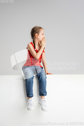 Image of Happy kid, girl isolated on white studio background. Looks happy, cheerful, sincere. Copyspace. Childhood, education, emotions concept