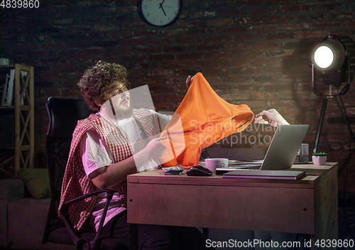 Image of Young happy Caucasian man doing shopping online through laptop.