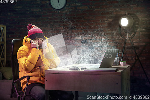Image of Young man in bright yellow puffy jacket meeting winter on virtual video call.