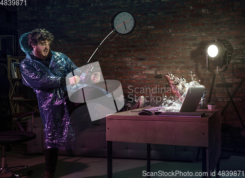 Image of Young man, fisherman catching a fish through laptop at home. Virtual reality