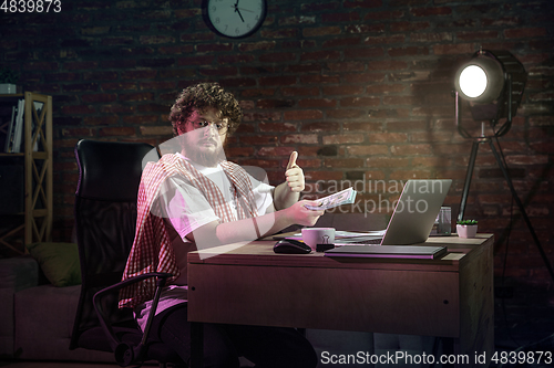 Image of Young happy Caucasian man doing shopping online through laptop.