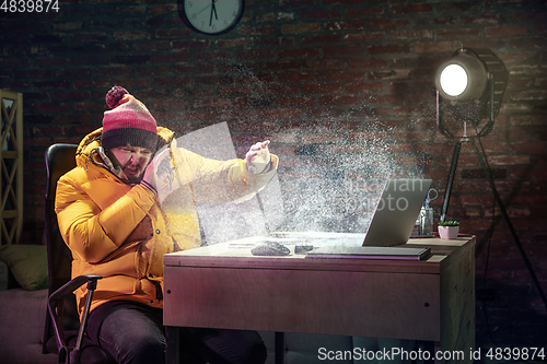 Image of Young man in bright yellow puffy jacket meeting winter on virtual video call.