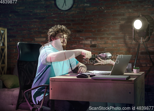 Image of Young happy Caucasian man doing shopping online through laptop.