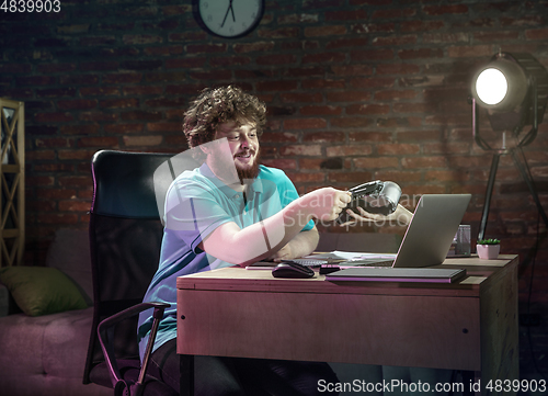 Image of Young happy Caucasian man doing shopping online through laptop.