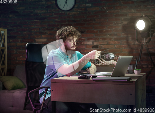 Image of Young happy Caucasian man doing shopping online through laptop.