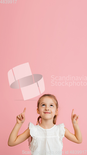 Image of Pretty caucasian girl portrait isolated on pink studio background with copyspace