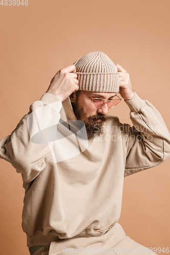 Image of Portrait of Caucasian man in glasses and hat isolated on light background.