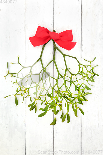 Image of Christmas Mistletoe with Red Bow on Rustic Wood 