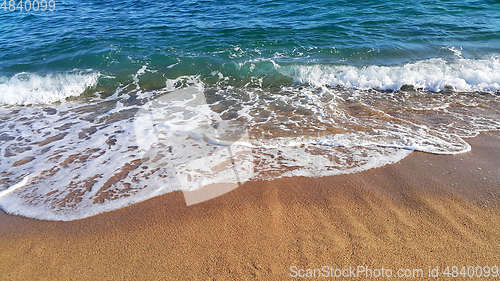 Image of Sea wave with white foam in the coastal sand