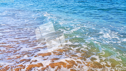 Image of Sea water with white foam in the coastal sand