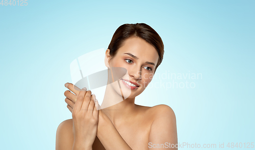 Image of woman applying moisturizing cream to her hand