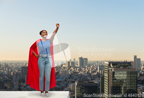 Image of happy african american woman in red superhero cape