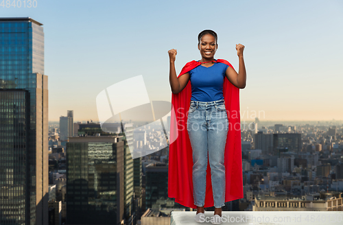 Image of happy african american woman in red superhero cape