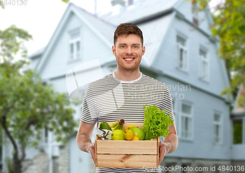 Image of smiling man with food in wooden box over house