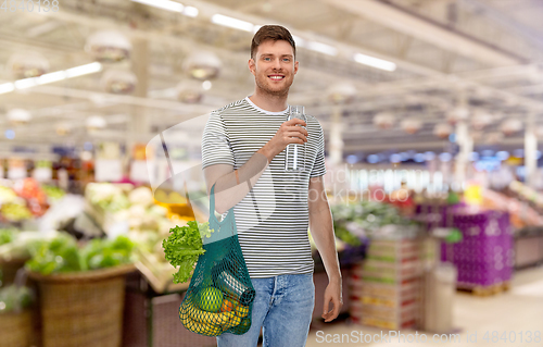 Image of man with food in bag and water in glass bottle