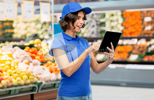 Image of delivery girl with tablet pc at grocery store