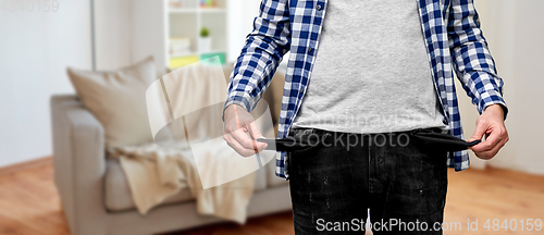 Image of close up of man showing empty pockets at home