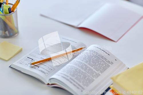 Image of books, pencil and school supplies on table