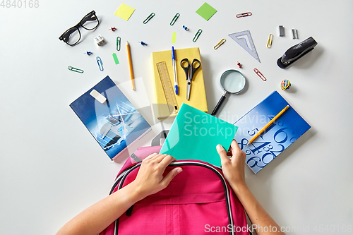 Image of hands with backpack, books and school supplies