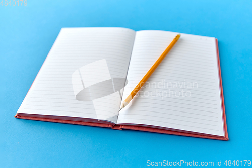 Image of open notebook with pencil on blue background