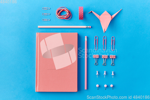 Image of pink notebook, pins, clips, pencils and rubbers