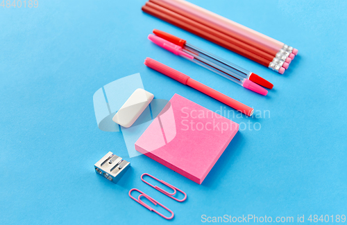 Image of pink sticky notes, pens, pencils, clips and eraser