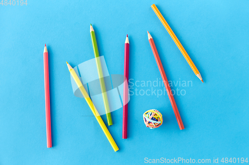 Image of coloring pencils and rubber bands on blue