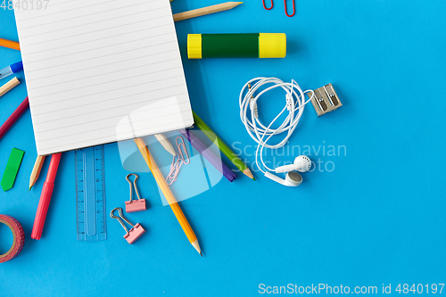 Image of notebook and school supplies on blue background