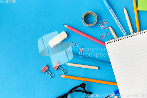 Image of notebook and school supplies on blue background