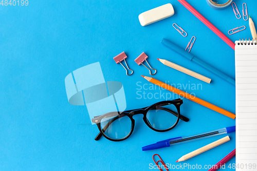 Image of notebook and school supplies on blue background