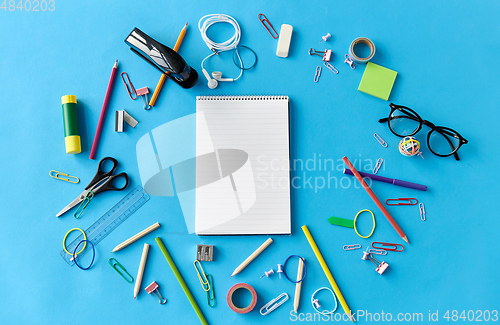 Image of notebook and school supplies on blue background