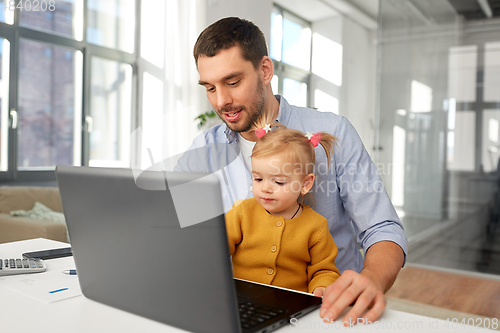 Image of working father with baby daughter at home office