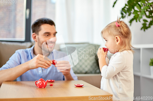 Image of father and daughter playing tea party at home