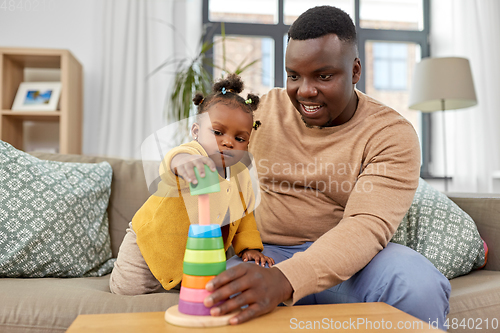 Image of african family playing with baby daughter at home