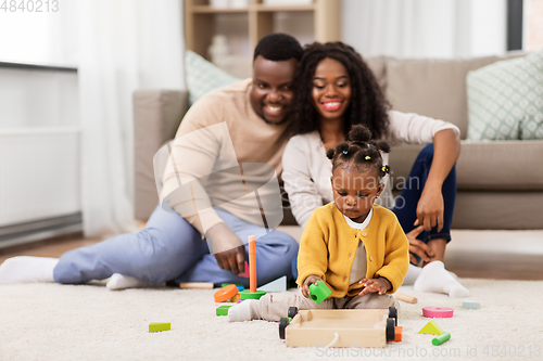 Image of african family playing with baby daughter at home