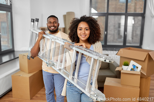 Image of happy couple with ladder moving to new home