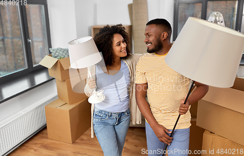 Image of happy couple packing boxes and moving to new home