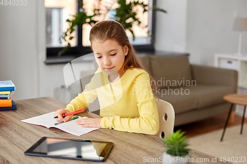 Image of student girl writing to notebook at home