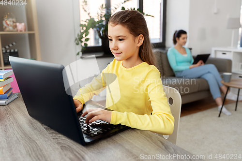 Image of student girl with laptop learning online at home