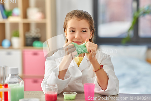 Image of girl playing with slime at home laboratory