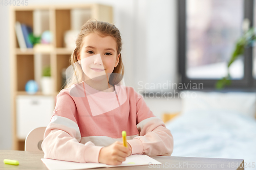 Image of girl with notebook and marker drawing at home