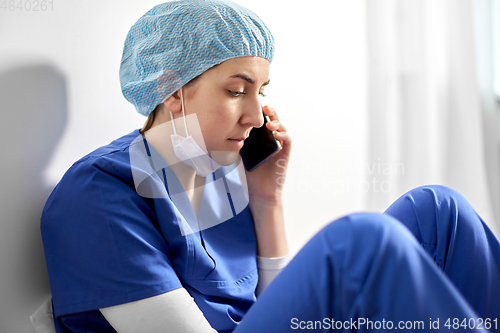 Image of sad doctor or nurse calling on smartphone