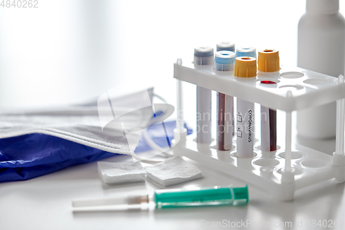 Image of beakers with coronavirus blood tests and syringe